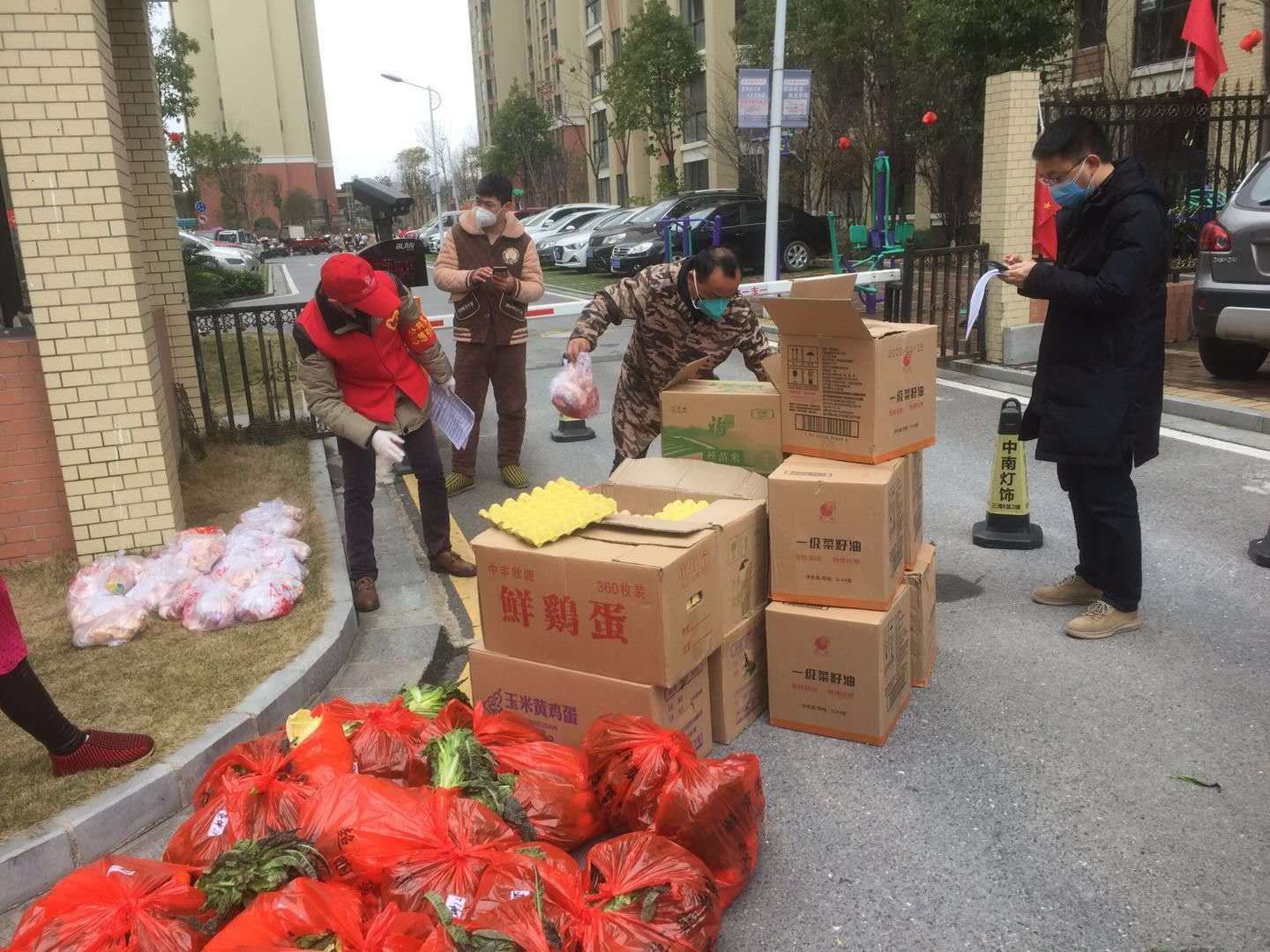 李宁同志（左一）为亚坤小区居民购买、分发物资.jpg